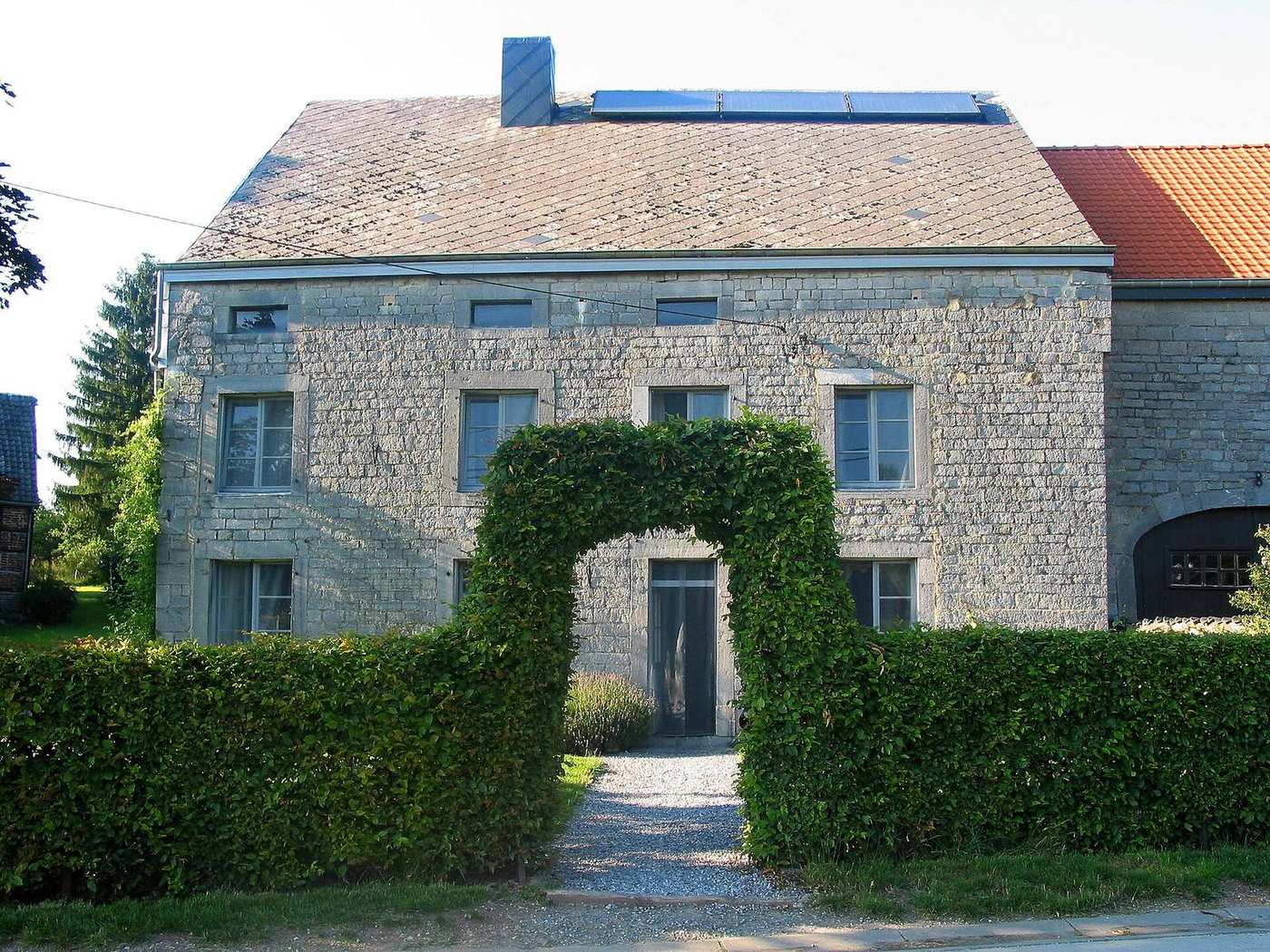 Stenen boerderij met een leien dak en zonnepanelen